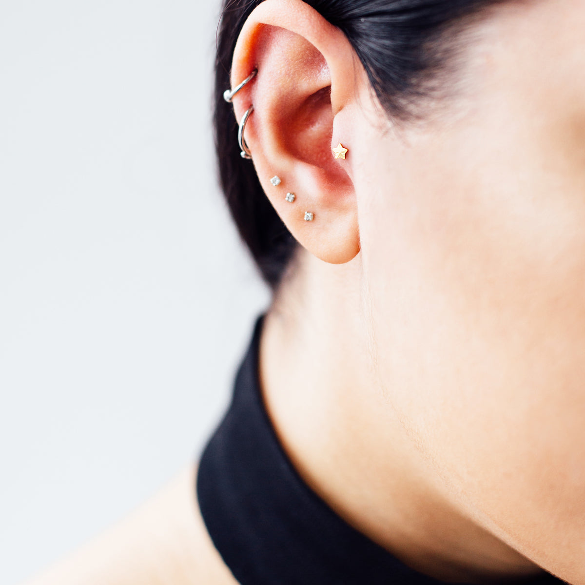 Solid Star Helix Tragus & Cartilage Ear Piercing On Model - Titanium